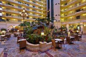 劳德代尔堡Embassy Suites by Hilton Fort Lauderdale 17th Street的酒店大堂设有桌椅,大楼宽敞。