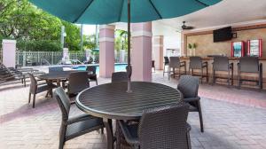 黎明城森赖斯索格拉斯米尔斯希尔顿逸林酒店的一个带桌椅和遮阳伞的庭院
