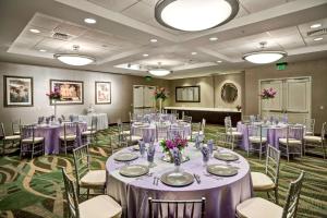 埃斯特罗迈尔斯堡德尔埃斯特罗大使套房酒店的宴会厅配有桌椅和紫色的桌布