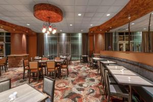拉夫兰Embassy Suites by Hilton Loveland Conference Center的一间在房间内配有桌椅的餐厅