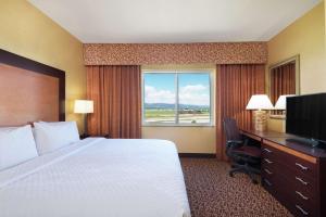 拉夫兰Embassy Suites by Hilton Loveland Conference Center的配有一张床、一张书桌和一扇窗户的酒店客房