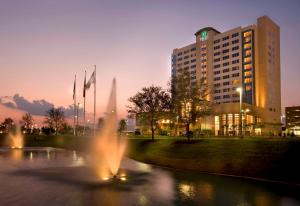 休斯顿Embassy Suites by Hilton Houston-Energy Corridor的池塘前有喷泉的建筑