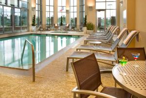 休斯顿Embassy Suites by Hilton Houston-Energy Corridor的一座配有桌椅的酒店游泳池