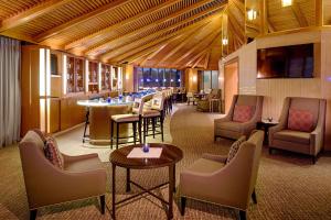 休斯顿休斯顿格林威广场希尔顿逸林酒店的酒店大堂设有酒吧和桌椅
