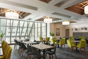 印第安纳波利斯Embassy Suites by Hilton Indianapolis Downtown的用餐室设有桌椅和窗户。