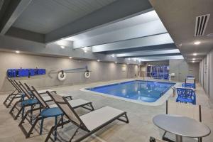 大急流城Home2 Suites By Hilton Grand Rapids North的一个带椅子和桌子的大型游泳池