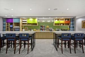 大急流城Home2 Suites By Hilton Grand Rapids North的一个带蓝色椅子和柜台的大厨房