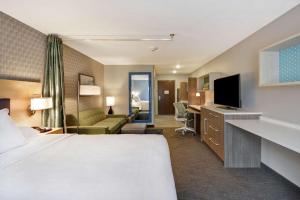大急流城Home2 Suites By Hilton Grand Rapids North的酒店客房设有床和客厅。