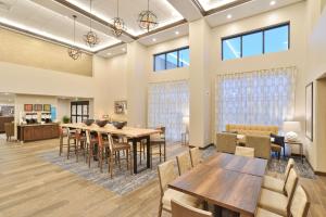 梅诺莫尼Hampton Inn & Suites Menomonie-UW Stout的用餐室设有桌椅和窗户。