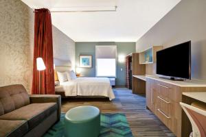 昆斯伯里Home2 Suites by Hilton Queensbury Lake George的酒店客房,配有床和电视