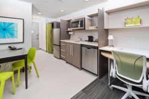 纽瓦克Home2 Suites By Hilton Newark Airport的一间厨房,里面配有桌椅