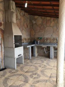 里奥迪孔塔斯Casa De Benedictis Rio de Contas的厨房配有炉灶和石墙