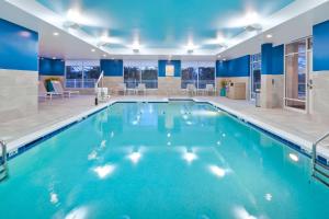 Buzzards BayHampton Inn Cape Cod Canal的蓝色的大游泳池,位于酒店客房内