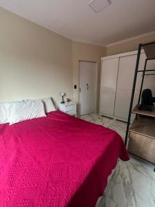 圣维森特岛Apartamento em Ilha Porchat的一间卧室配有一张带红色毯子的大床