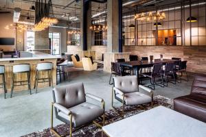 拉威Watt Hotel Tapestry Collection by Hilton的大堂设有桌椅和酒吧。
