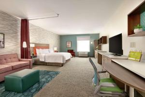 伊斯顿Home2 Suites By Hilton Easton的大型酒店客房,配有一张床和一张书桌