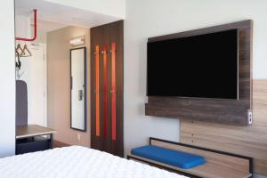 劳德代尔堡Tru By Hilton Fort Lauderdale Downtown-Flagler Village的卧室配有壁挂式平面电视