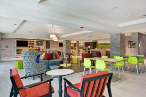 杰克逊维尔Home2 Suites By Hilton Jacksonville South St Johns Town Ctr的大堂内的餐厅,配有五颜六色的桌椅