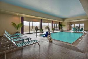 威奇托Home2 Suites by Hilton Wichita Northeast的一个带2把躺椅和秋千的大型游泳池