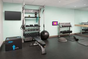 博福特Tru by Hilton Beaufort, Sc的一间设有健身房、举重器材和电视的客房