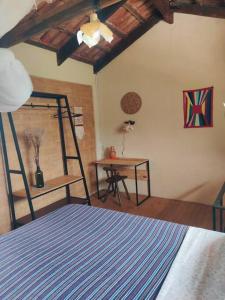 卡瓦坎特Rosa dos Ventos Chalés的一间卧室,一间设有一张床和一张书桌的房间