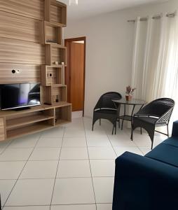 费拉迪圣安娜Ap 2/4 Prox ao shopping的客厅配有桌椅和电视。
