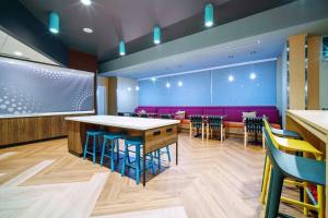 嘉年Tru By Hilton Goodyear Phoenix West, Az的餐厅配有桌椅和紫色沙发