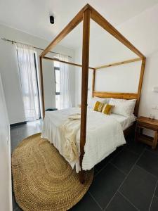 帕杰Island style 2-bedroom apartment with pool "Ilava Boma"的一间卧室配有一张四柱天蓬床