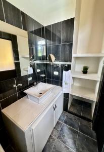 比亚维森西奥Cabaña La Betica的浴室设有白色水槽和黑色瓷砖