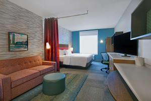 哥伦布Home2 Suites By Hilton Columbus的酒店客房设有沙发、床和书桌