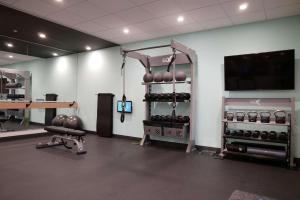 钱伯斯堡Tru By Hilton Chambersburg的一间设有健身房的房间,里面装有一堆重量