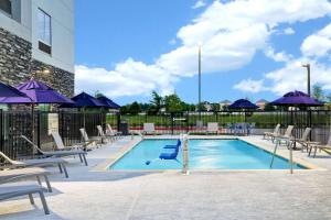 休斯顿Hampton Inn & Suites Houston East Beltway 8, Tx的一个带躺椅和遮阳伞的游泳池