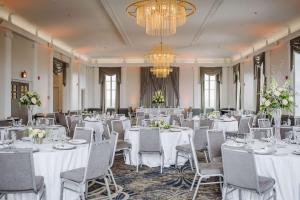埃尔克哈特Hotel Elkhart, Tapestry Collection By Hilton的宴会厅配有白色的桌椅和吊灯。