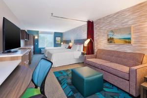 威尔明顿Home2 Suites Wilmington的酒店客房,配有床和沙发