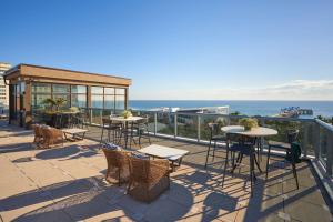 帕诺滩Home2 Suites By Hilton Pompano Beach Pier, Fl的一个带桌椅的庭院和大海