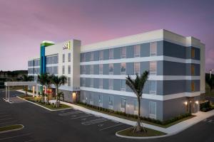 迈尔斯堡Home2 Suites by Hilton Fort Myers Airport的 ⁇ 染带停车场的办公楼