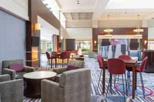 费尔法克斯Hilton Fairfax, Va的酒店大堂设有桌椅和酒吧