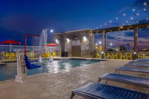 加尔维斯敦Home2 Suites Galveston, Tx的一个带滑梯的游泳池,一个夜间水上公园