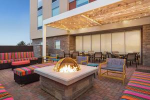 利斯堡Home2 Suites By Hilton Leesburg, Va的庭院设有火坑和桌椅