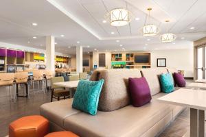 利斯堡Home2 Suites By Hilton Leesburg, Va的自助餐厅里摆放着带丰富多彩枕头的沙发。