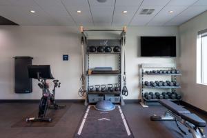 费耶特维尔Tru By Hilton Fayetteville Fort Bragg的一间设有健身房、举重器材和电视的房间