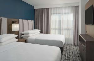 休斯顿The Chifley Houston, Tapestry Collection by Hilton的酒店客房设有两张床和电视。