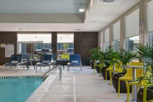 费耶特维尔Home2 Suites By Hilton Fayetteville North的大楼内一个带桌椅的游泳池