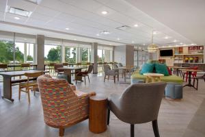肯特伍德Home2 Suites By Hilton Grand Rapids Airport的一间设有桌椅和桌上电脑的等候室
