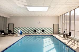 沃思堡Doubletree By Hilton Fort Worth South的大楼内一个带桌椅的游泳池