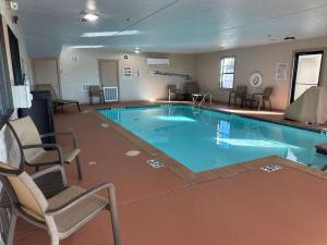 CaleraBest Western Halito Inn的酒店客房的大型游泳池配有两把椅子
