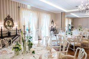 艾珍明希豪森城堡酒店的用餐室配有白色的桌子和白色的椅子