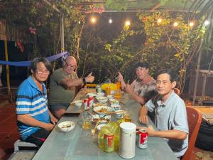 Tuy PhongĐức Lưu Quang Hotel Bình Thuận的一群坐在餐桌旁吃饭的人