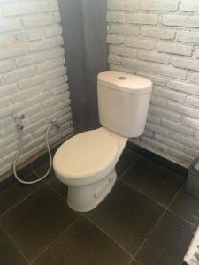 Kubutambahan布连民宿的浴室内设有一个白色的卫生间,配有软管