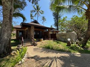 高兰Beach Bungalow at Lanta Resort的前面有棕榈树的房子